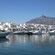 Un puerto repleto de botes cerca de departamentos y montañas
